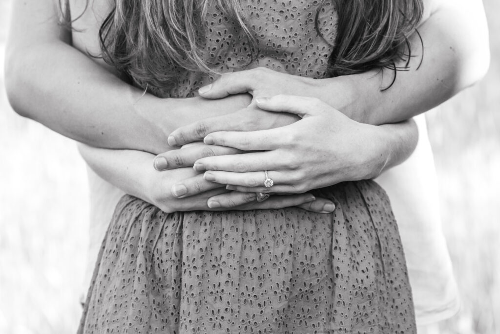 engaged couple clasping hands