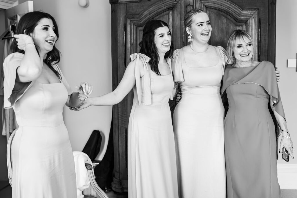 Bridesmaids with bride's mother hugging in black & white